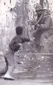 Konfrontation: ein israelischer Soldat trifft in Gaza auf ein steinewerfendes palaestinensisches Kind.